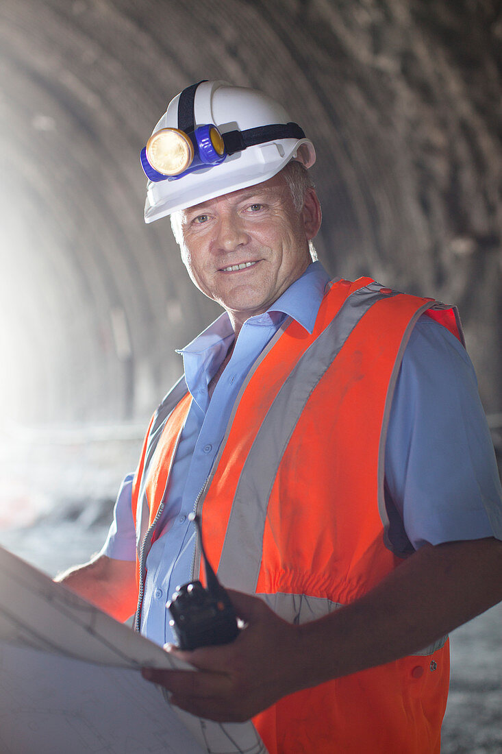 Businessman reading blueprints in tunnel