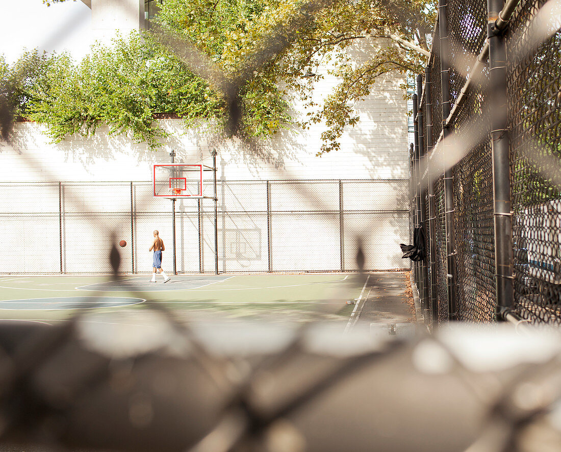 Man playing basketball on urban court