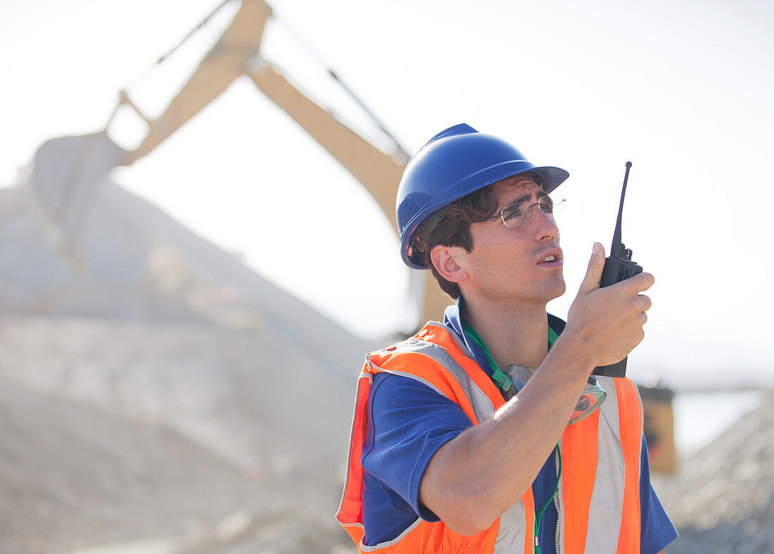 Worker using walkie-talkie in quarry