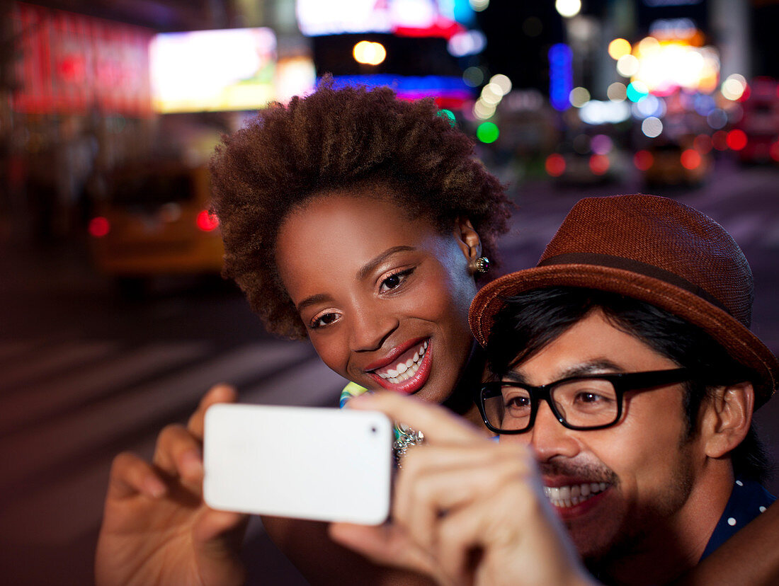 Couple taking pictures on city street