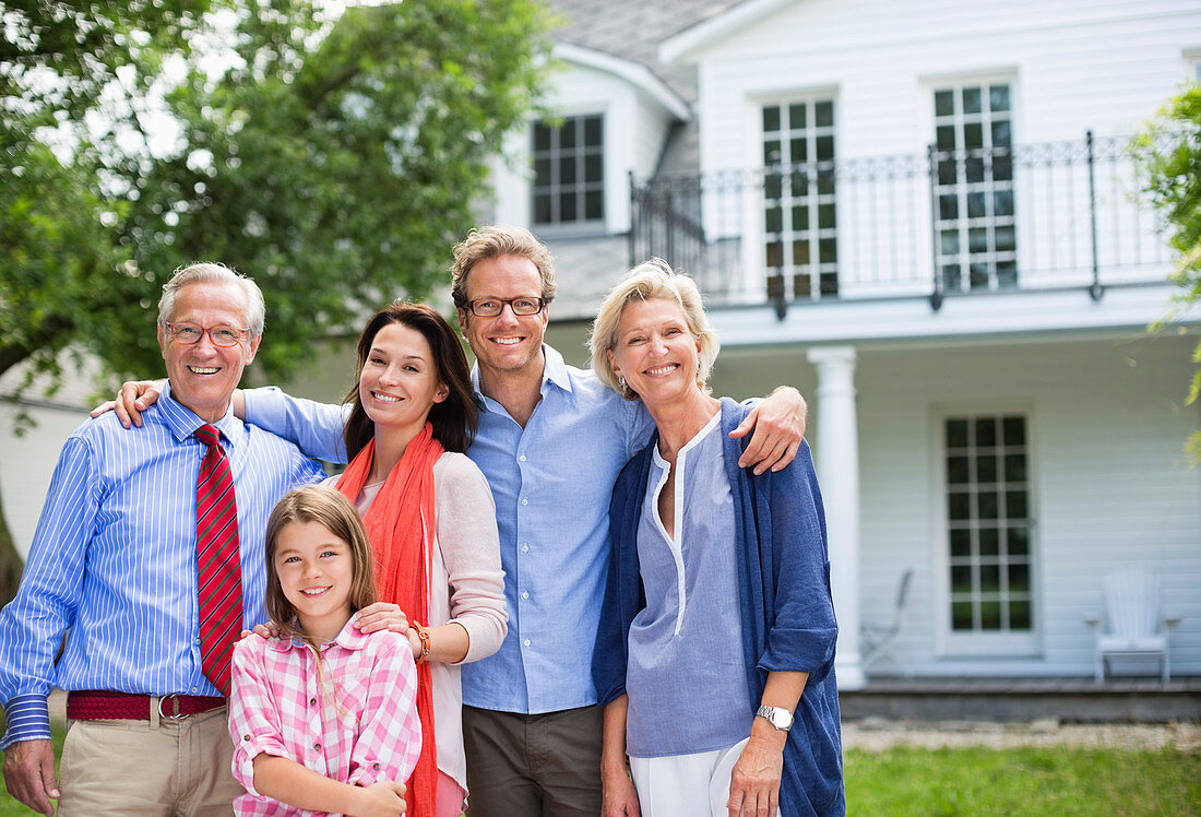 Family smiling together outside house