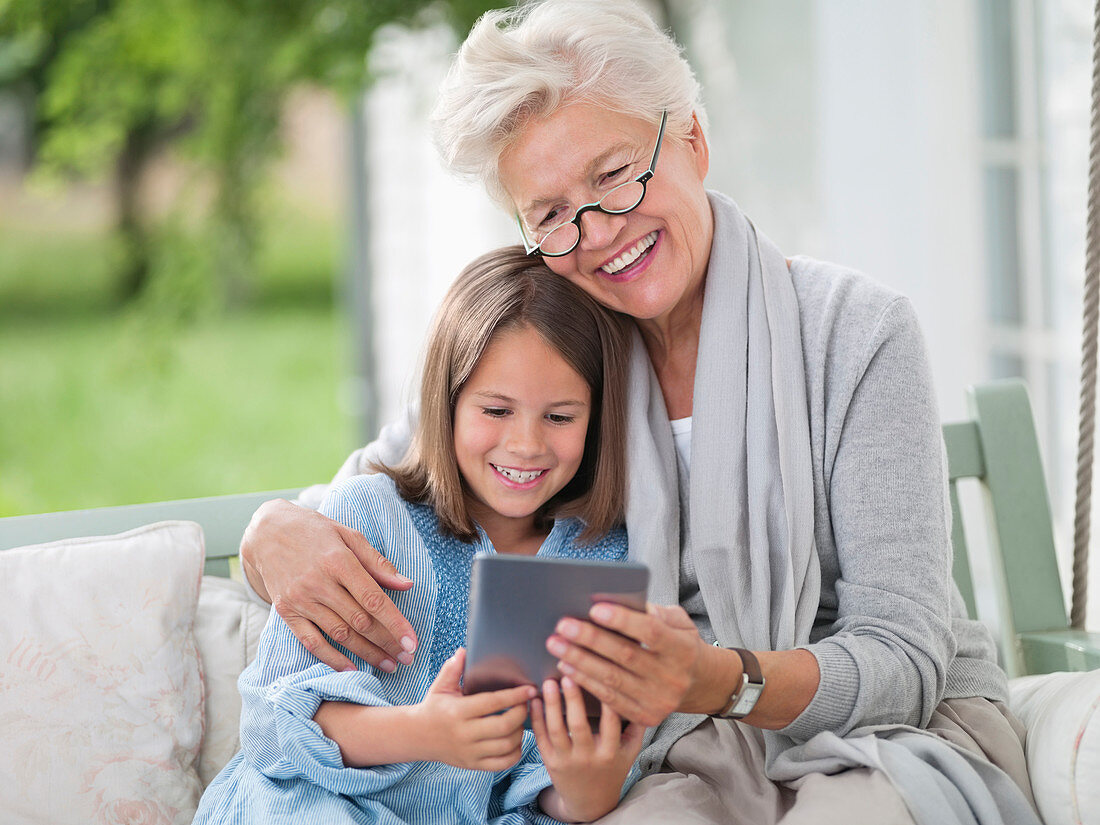 Woman and granddaughter using tablet