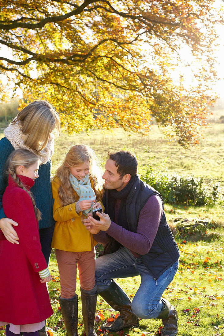 Family using cell phone together outdoors