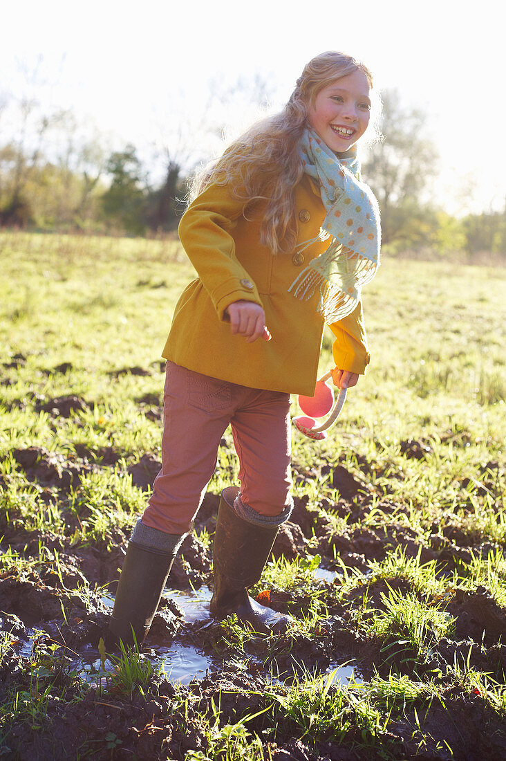 Girl wading in muddy field