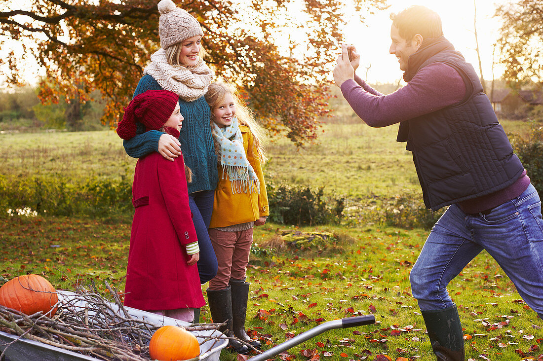 Father taking picture of family outdoors