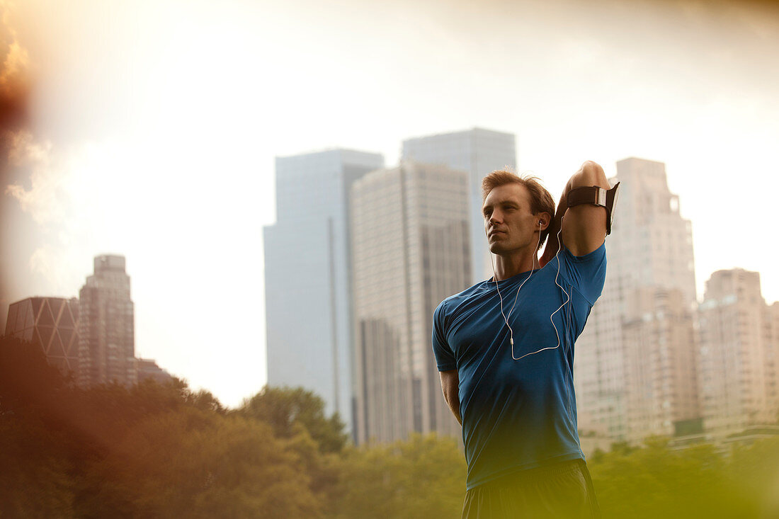 Runner stretching in urban park