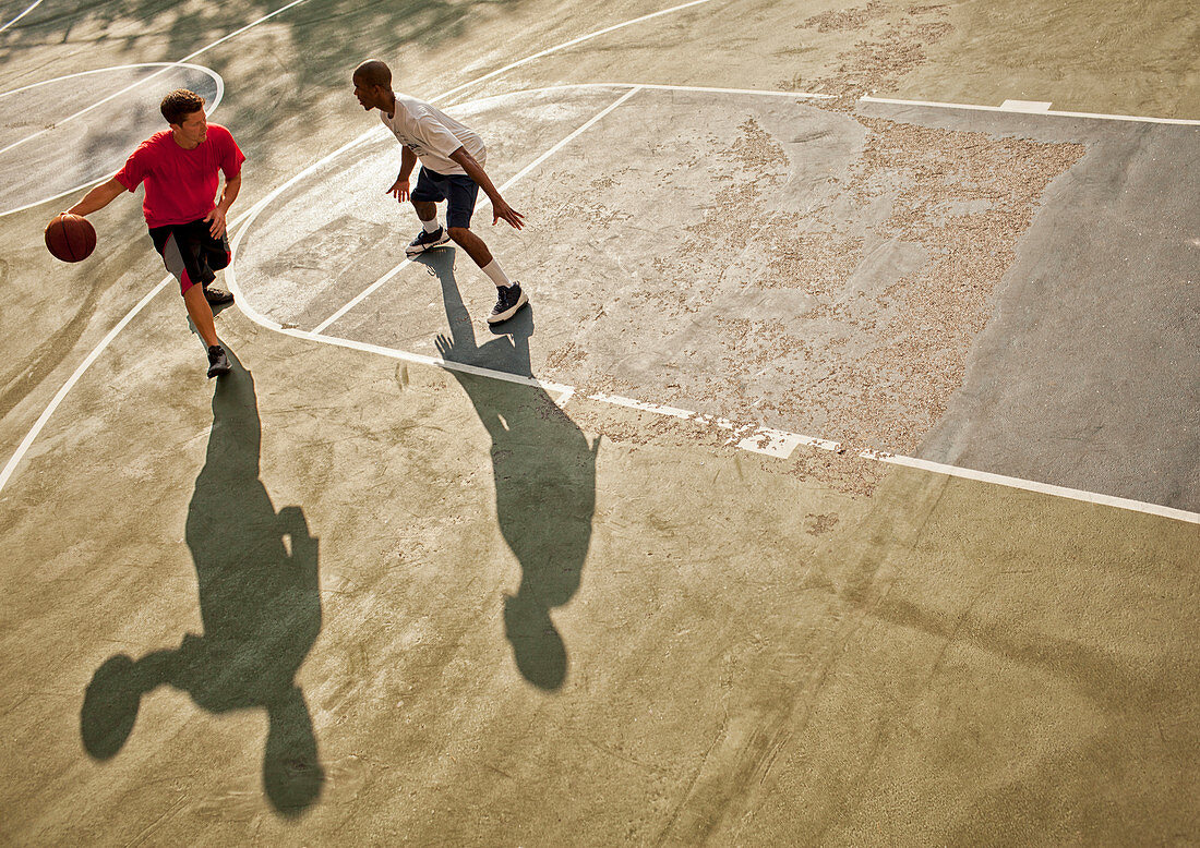 Men playing basketball on court