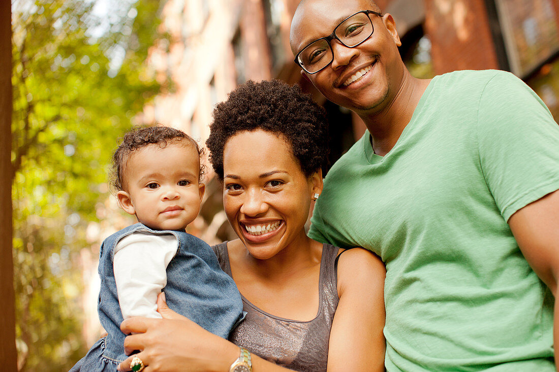 Smiling family standing outdoors