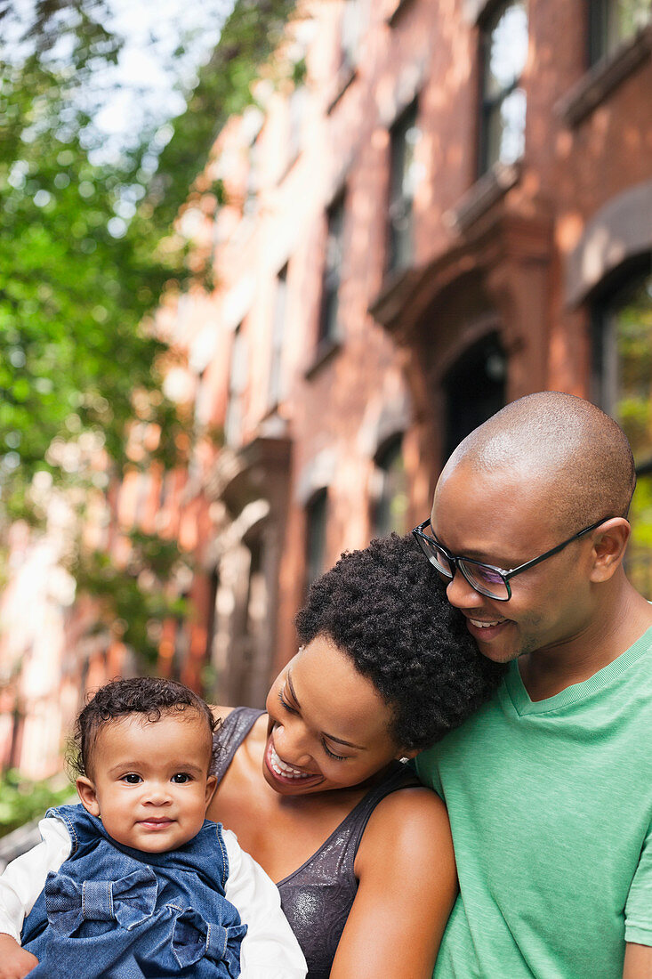 Family smiling together on city street