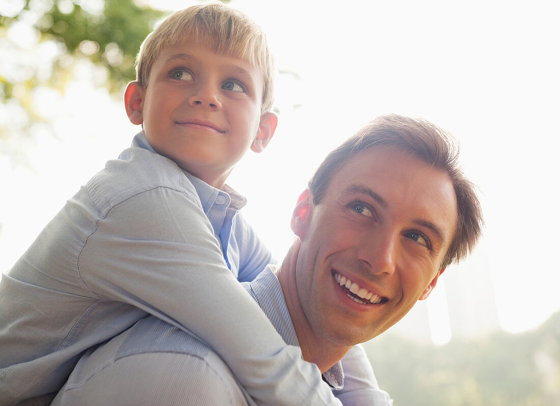 Man carrying son piggyback outdoors