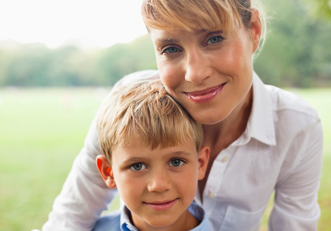 Smiling mother hugging son outdoors