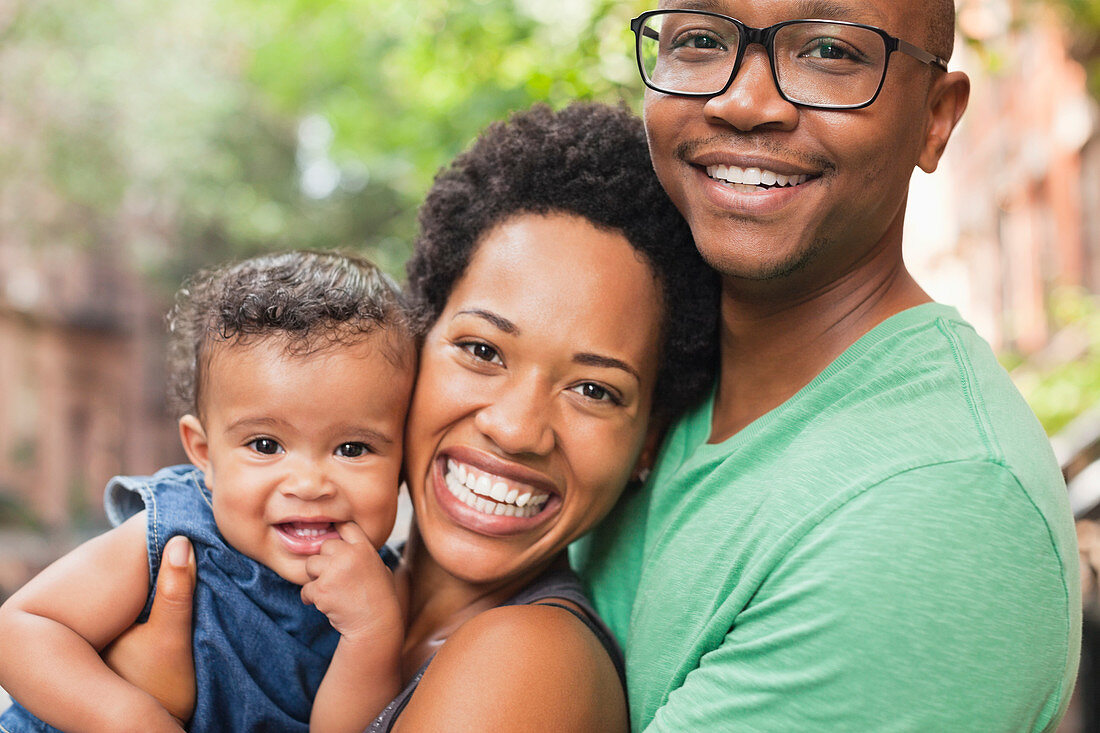 Family smiling together on city street