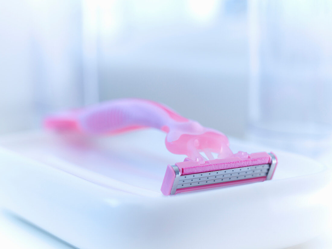 Close up of pink razor in bathroom