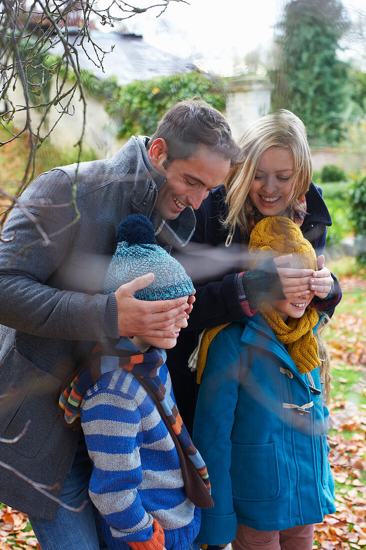 Parents covering children's eyes outdoors