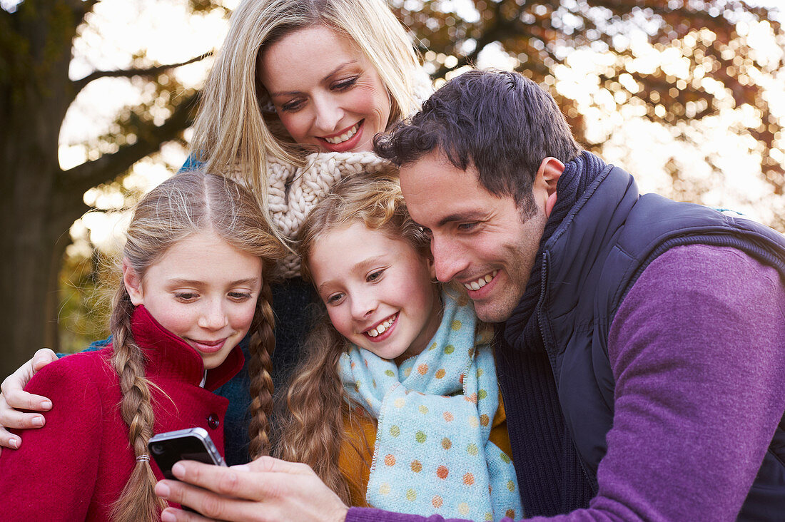 Family using cell phone outdoors