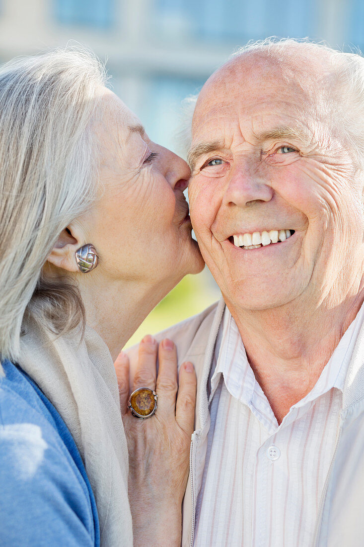 Smiling older couple kissing outdoors