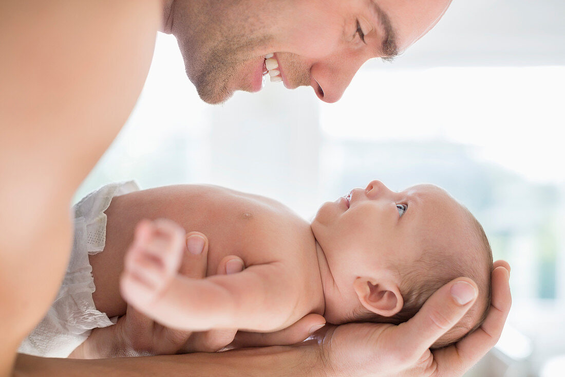 Father cradling newborn baby