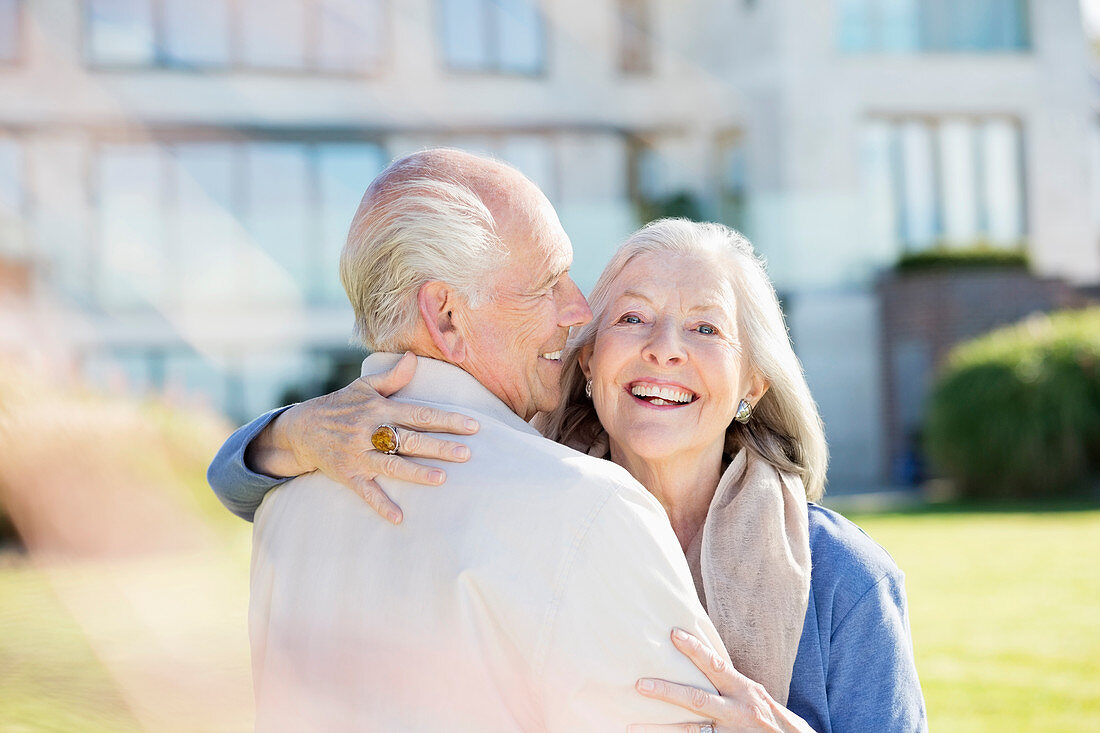 Older couple hugging outdoors