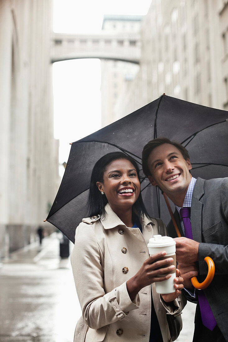 Business people holding umbrella