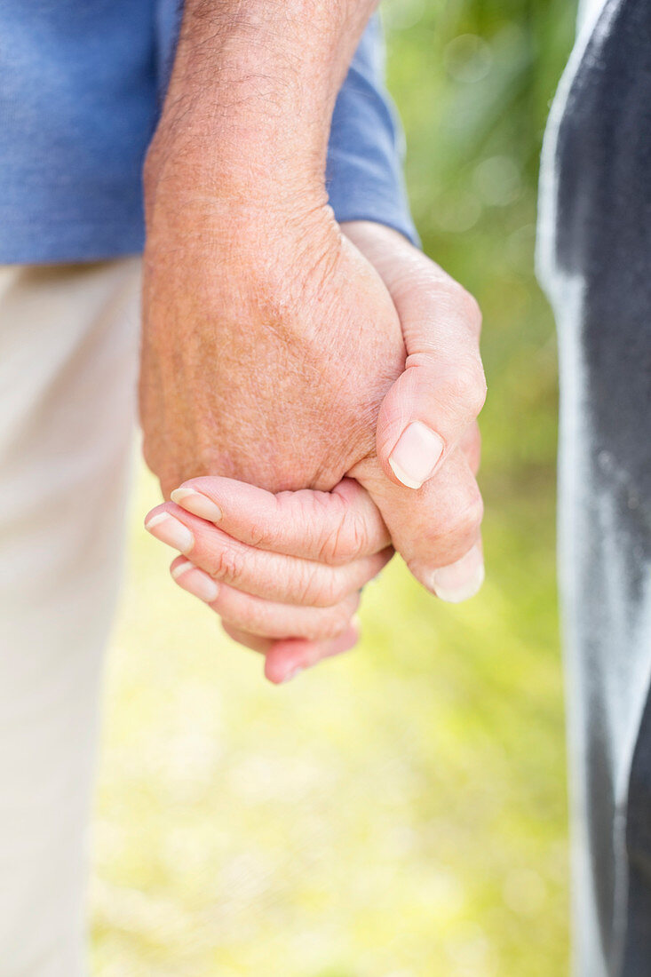 Older couple holding hands outdoors