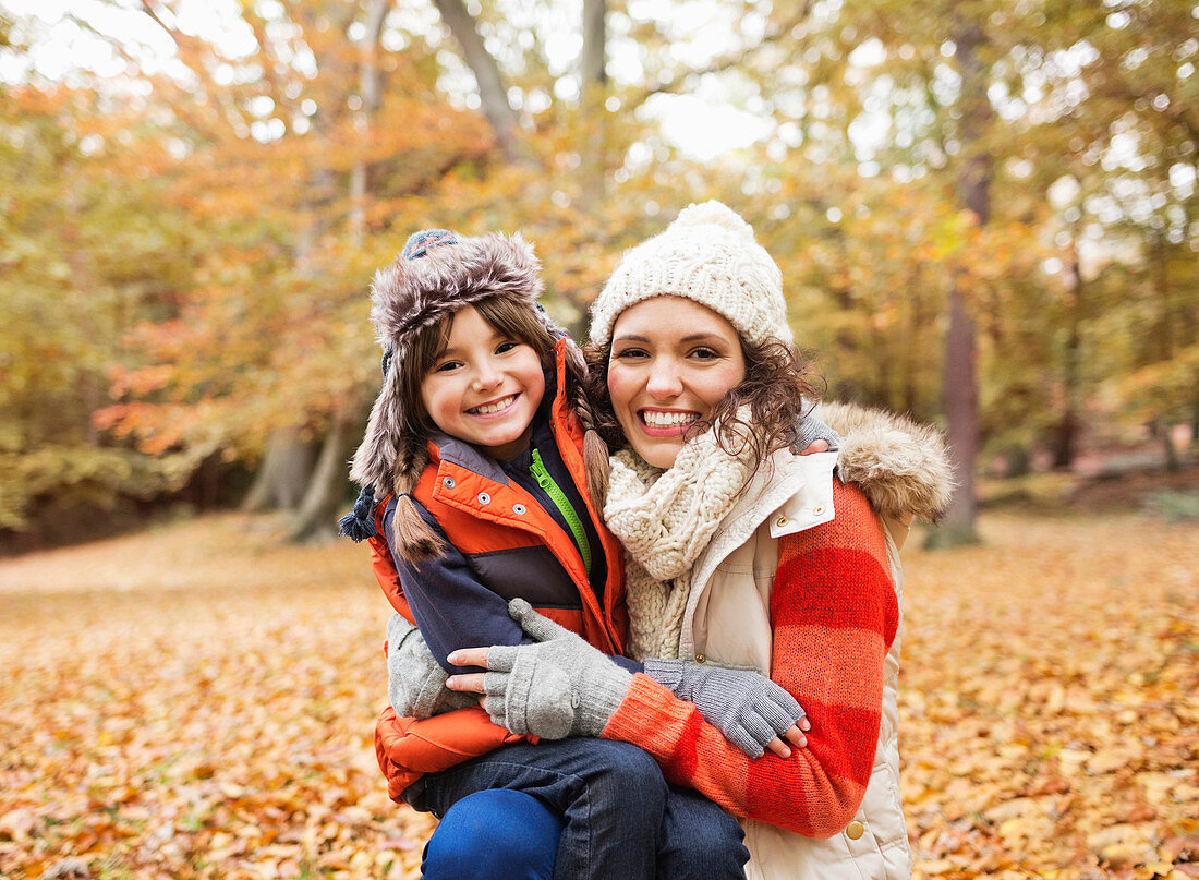 Mother and daughter in autumn leaves