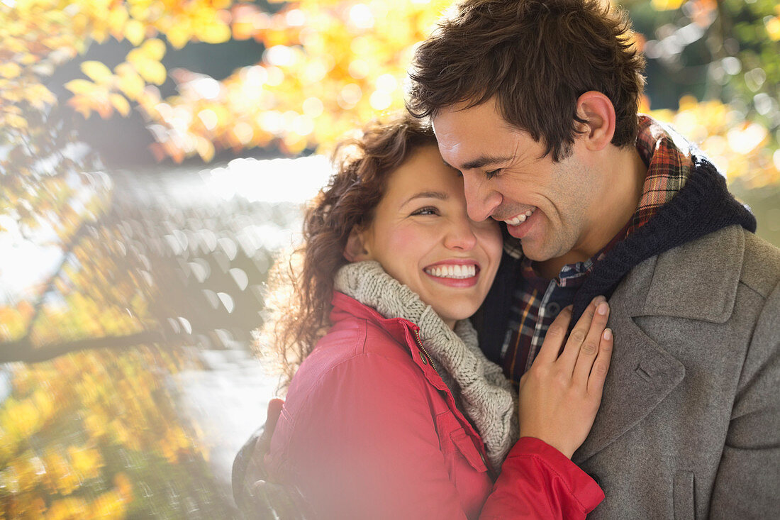 Smiling couple hugging in park