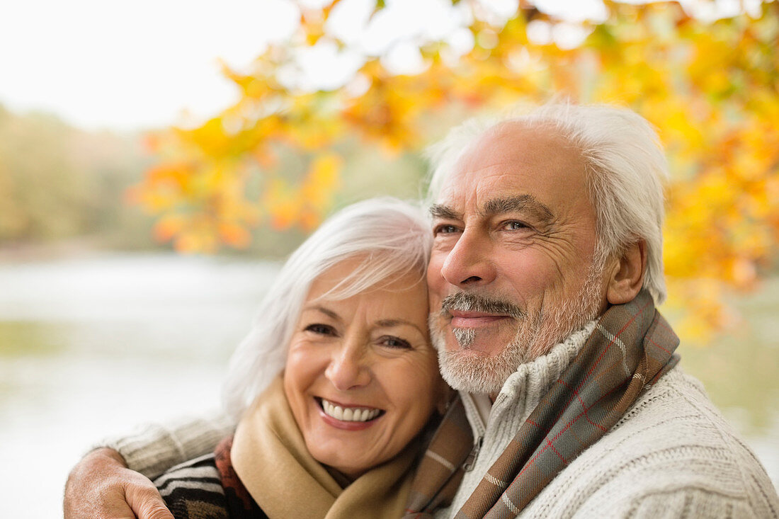 Older couple hugging in park