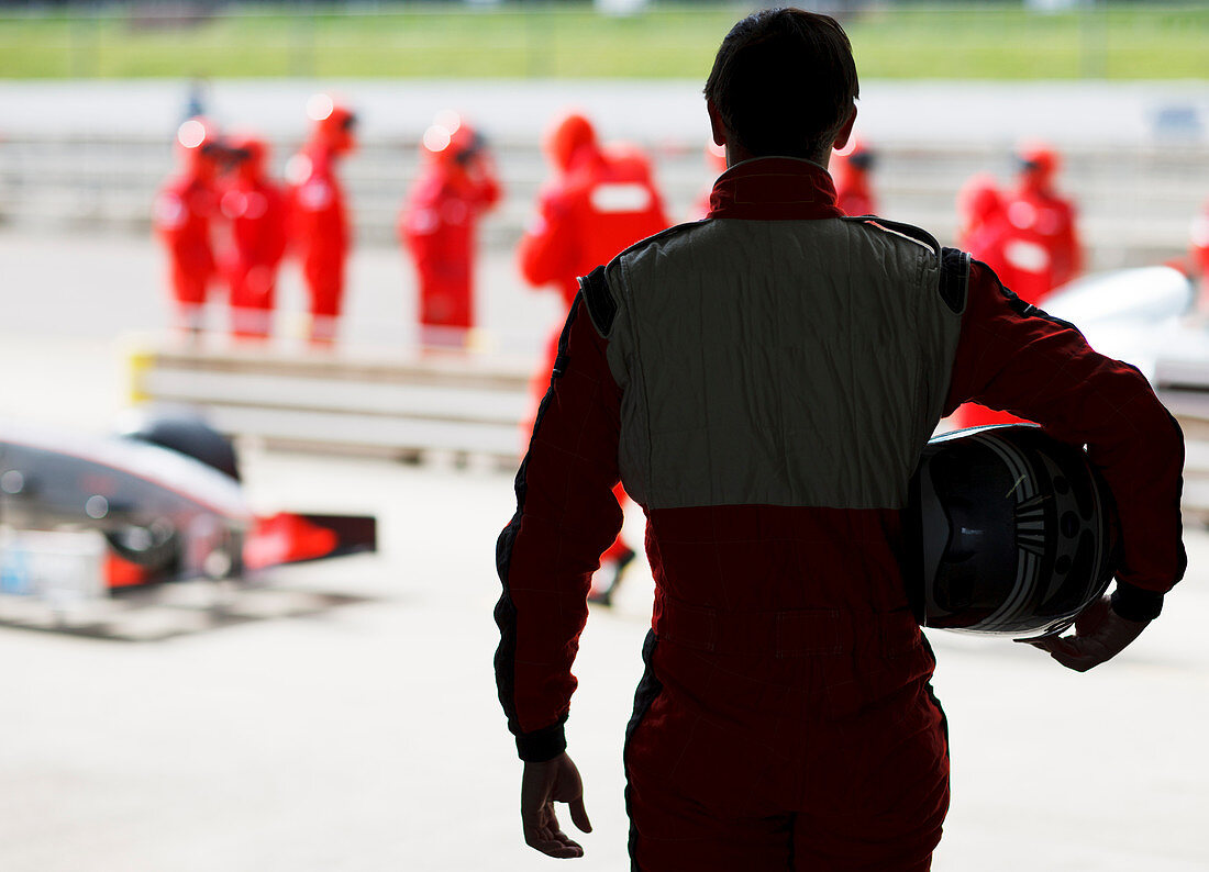 Racer carrying helmet on sidelines