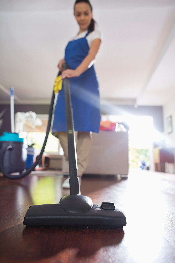 Woman vacuuming living room floor