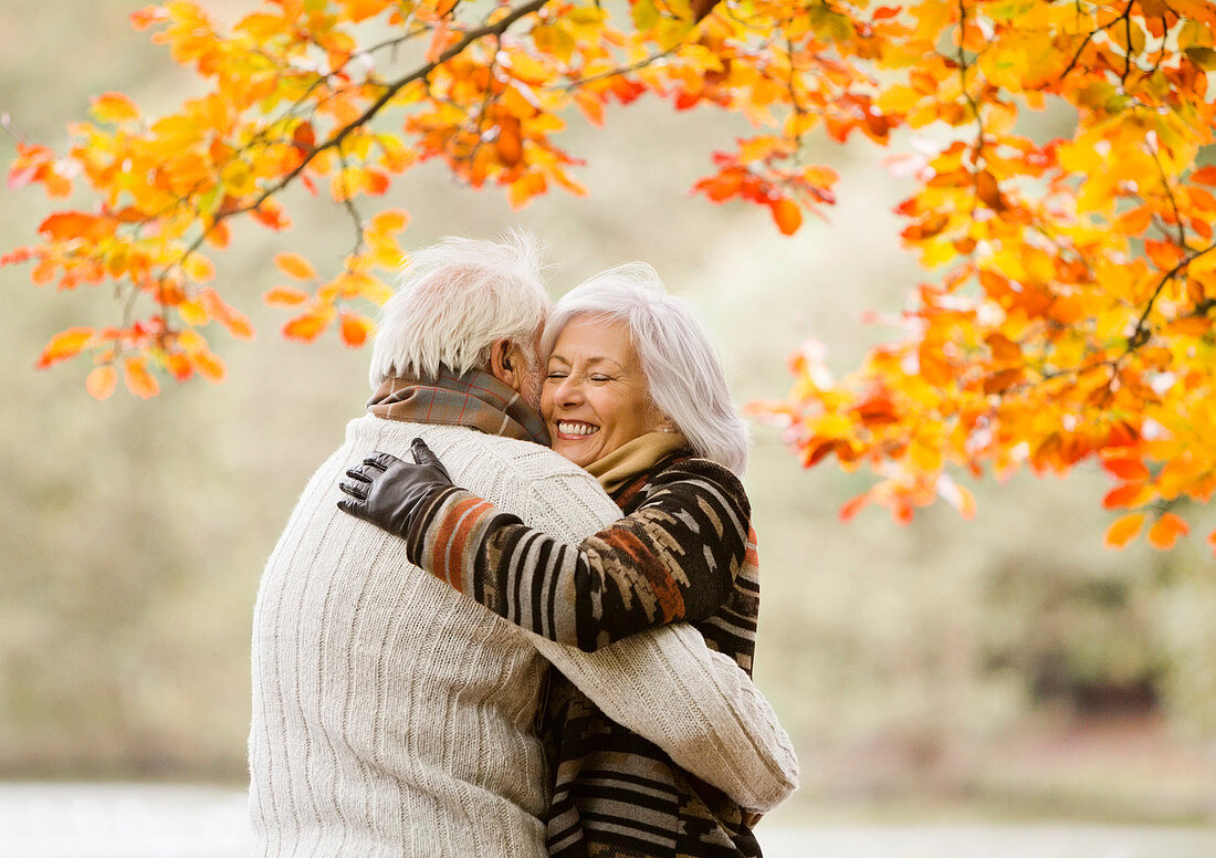 Older couple hugging in park