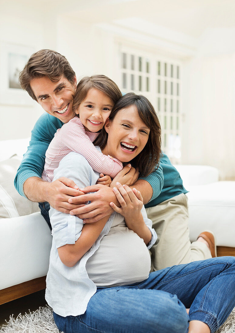 Family hugging in living room