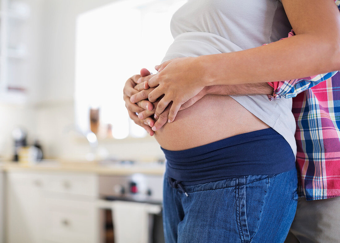 Man holding pregnant girlfriend's belly