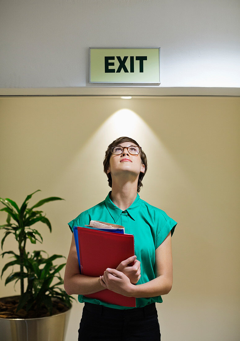 Businesswoman under office Exit sign