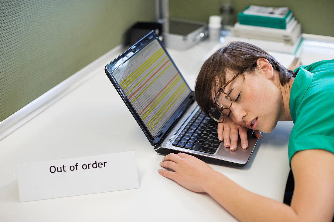 Businesswoman sleeping on laptop