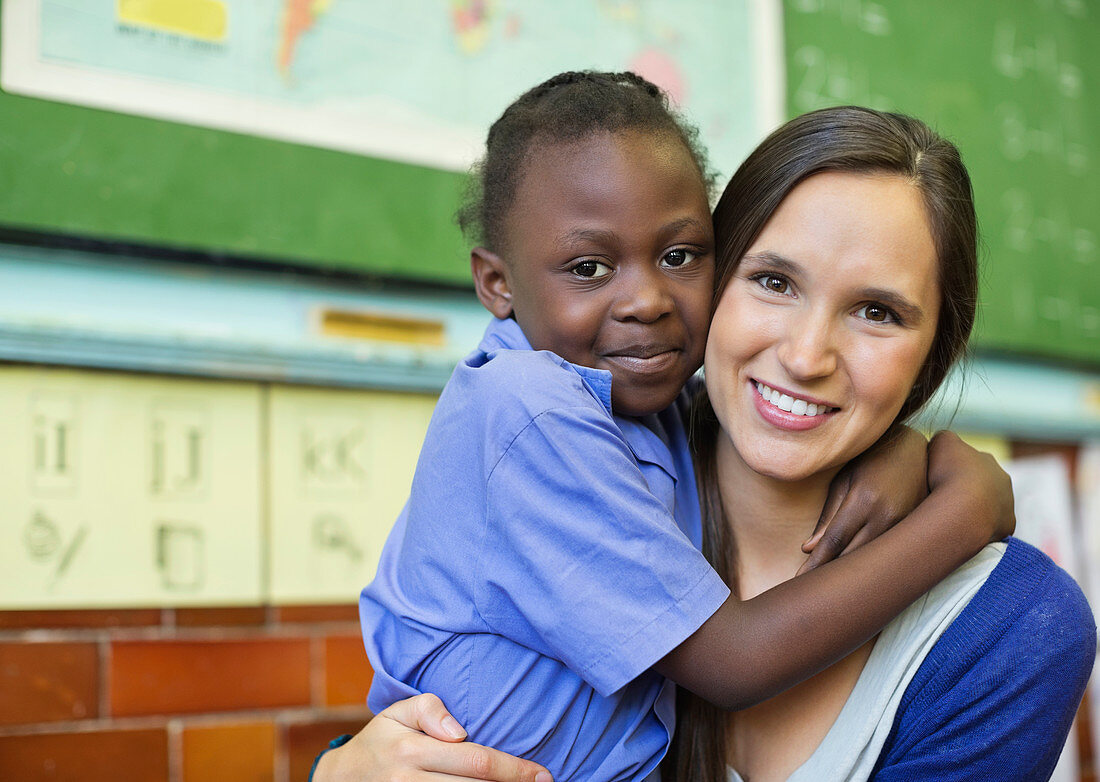 Teacher hugging student in class