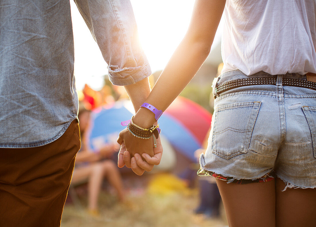 Couple holding hands at music festival