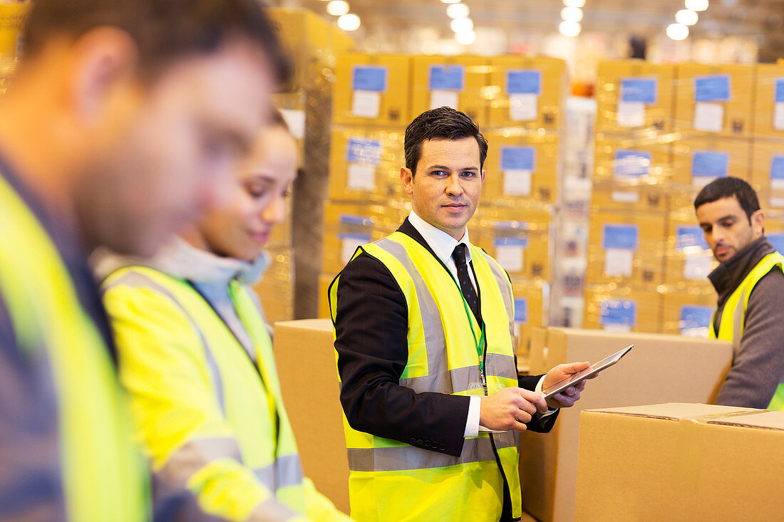Businessman and workers in warehouse