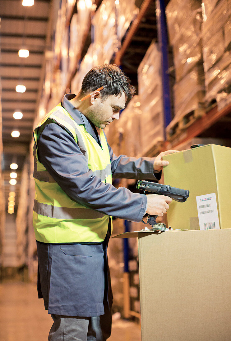Worker scanning box in warehouse