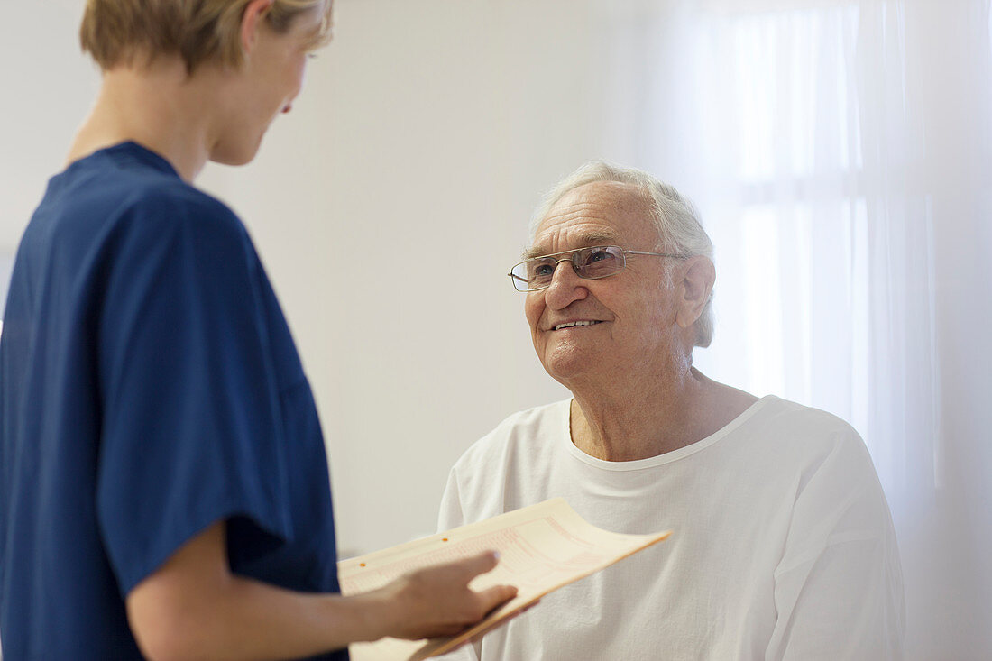 Nurse talking to older patient room