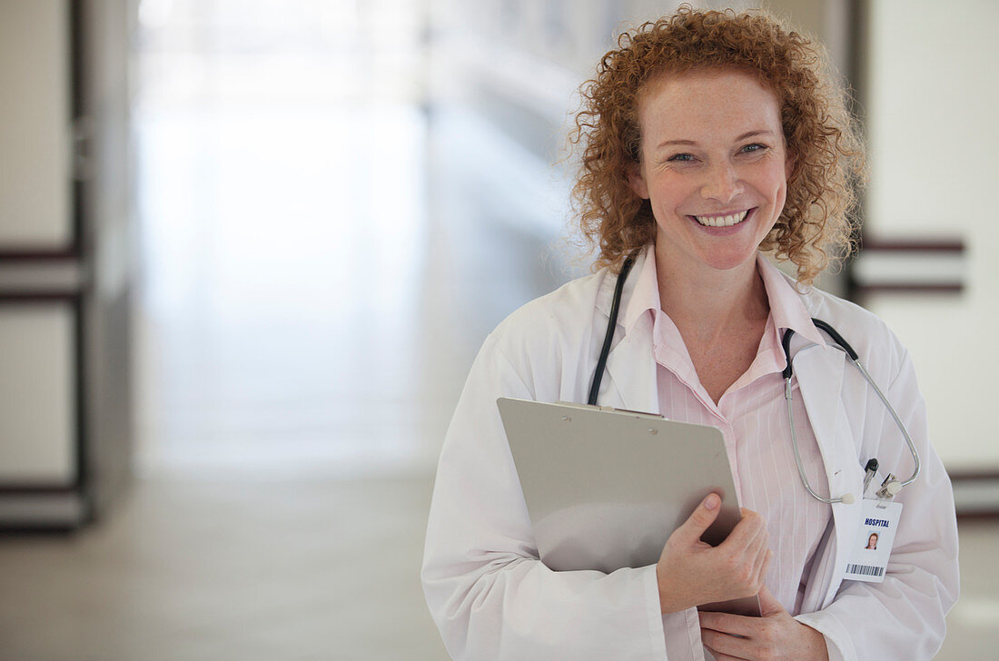 Doctor carrying clipboard hallway