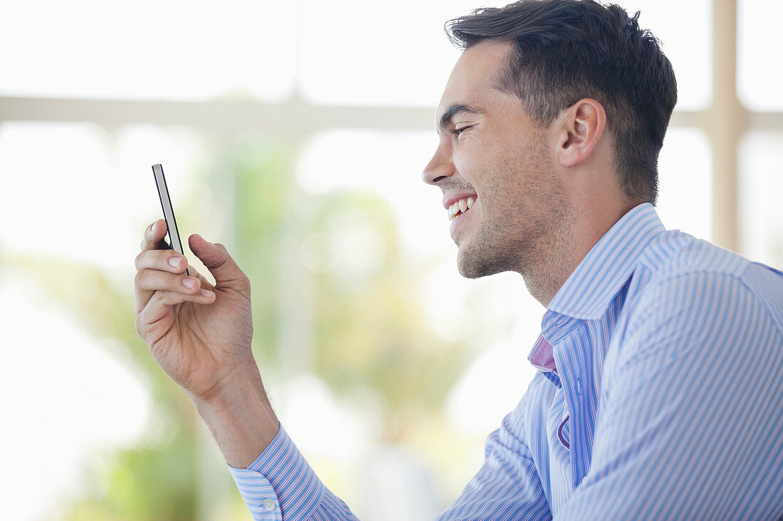 Businessman using cell phone in office