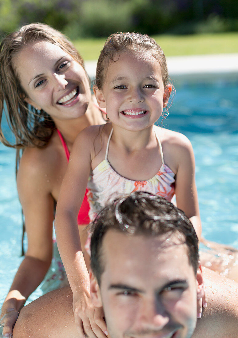 Family smiling in swimming pool