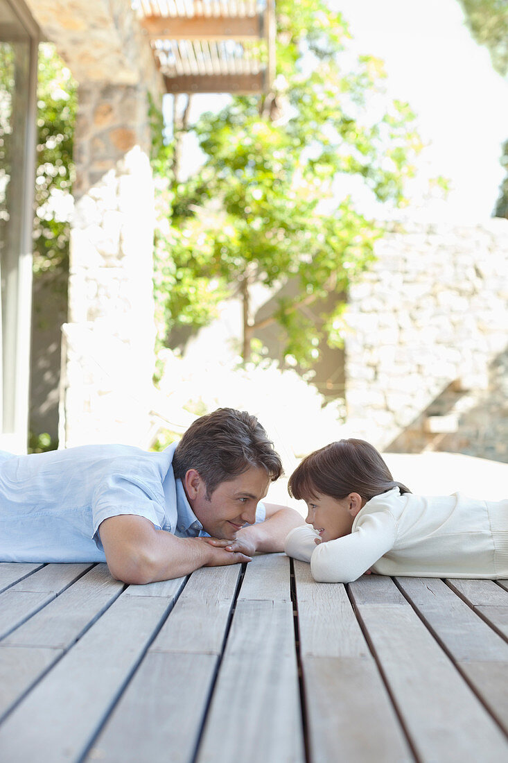 Father and daughter laying on porch