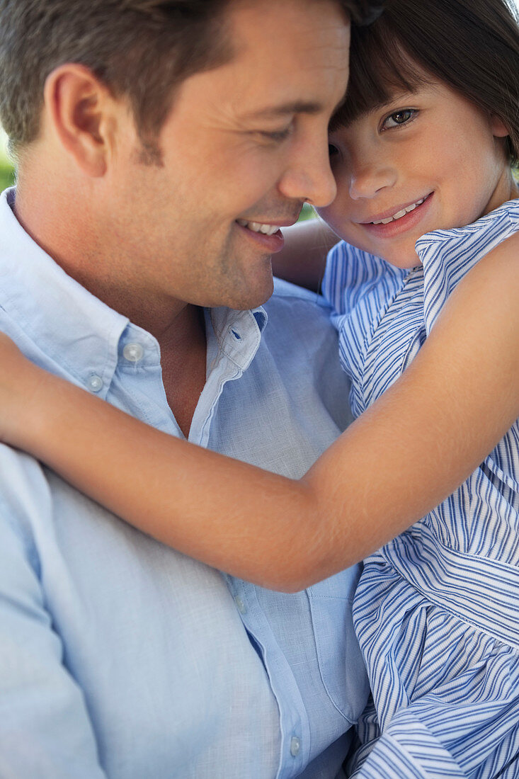 Father and daughter hugging outdoors