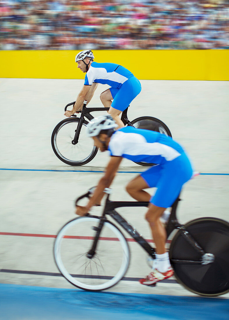 Track cyclists riding in velodrome