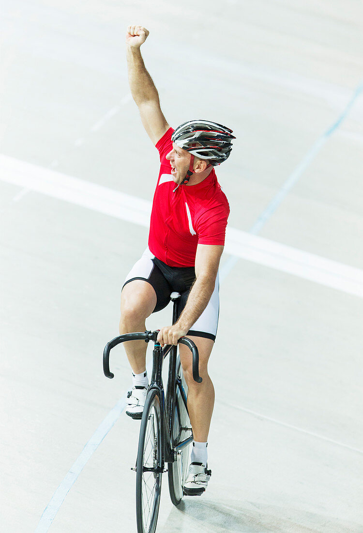 Track cyclist celebrating in velodrome