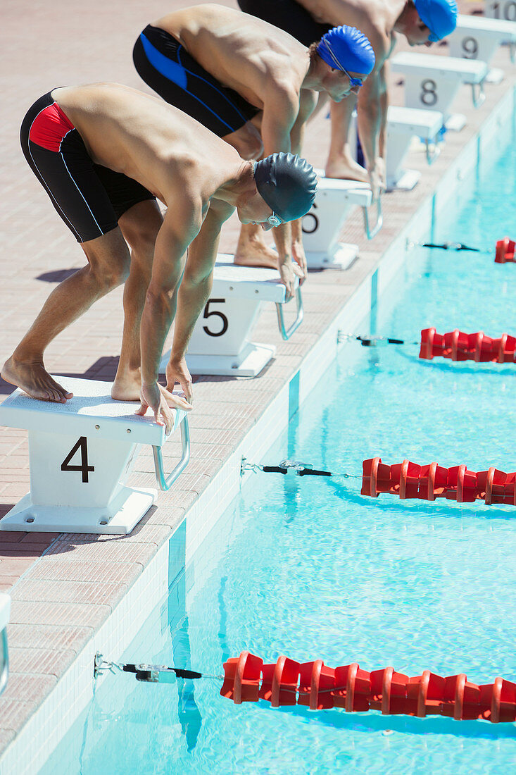 Swimmers poised at starting blocks