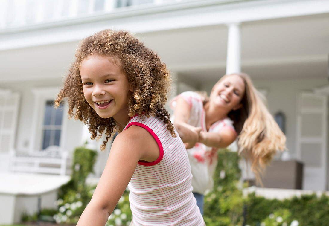 Mother and daughter playing outside house