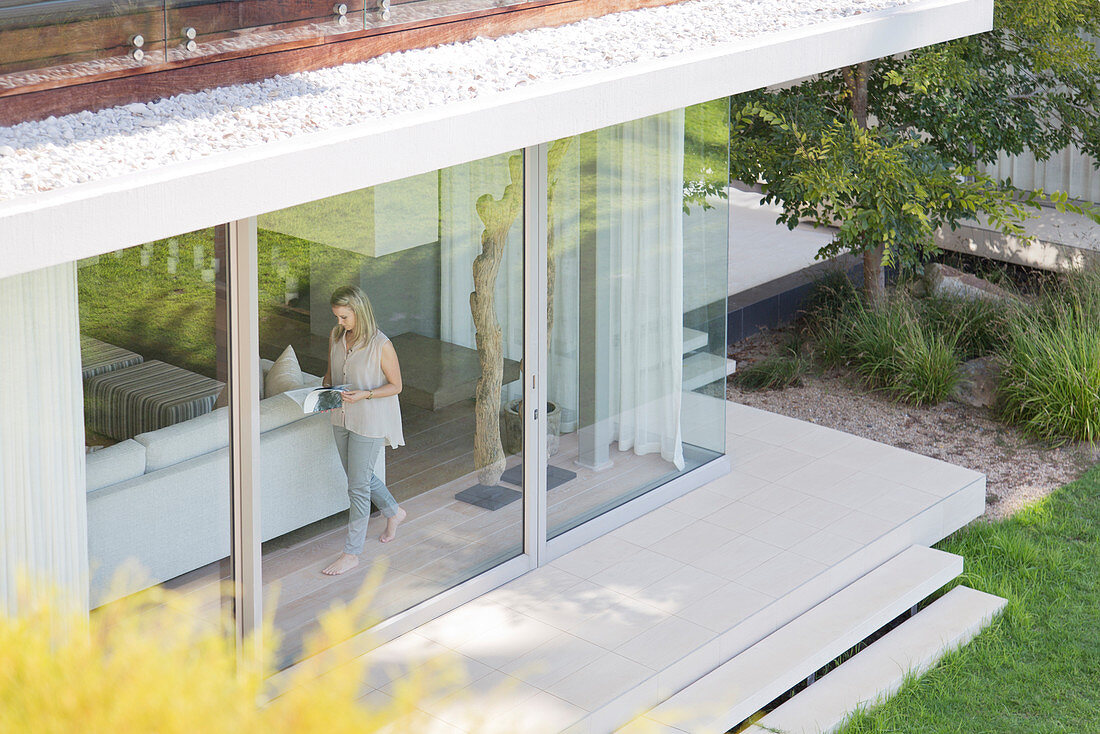 Woman walking along window inside house