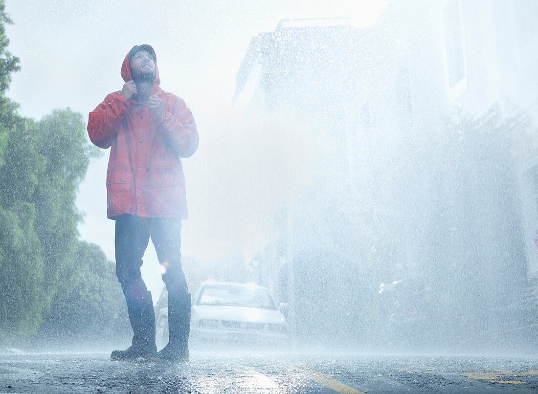 Man wearing raincoat in rainy street